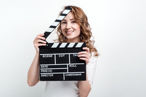 vecteezy_pretty-girl-with-a-movie-board-on-a-white-background_3542387